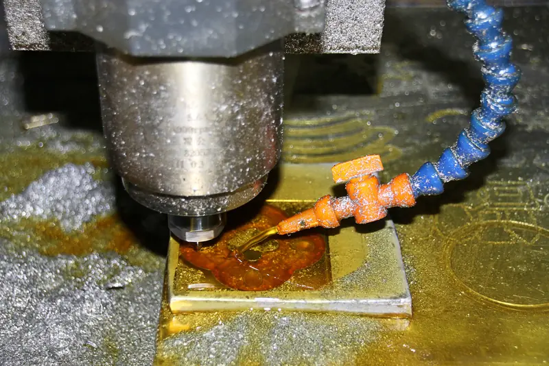 Wrzeciono frezarki CNC obrabiające płytkę metalu z doprowadzonym chłodziwem